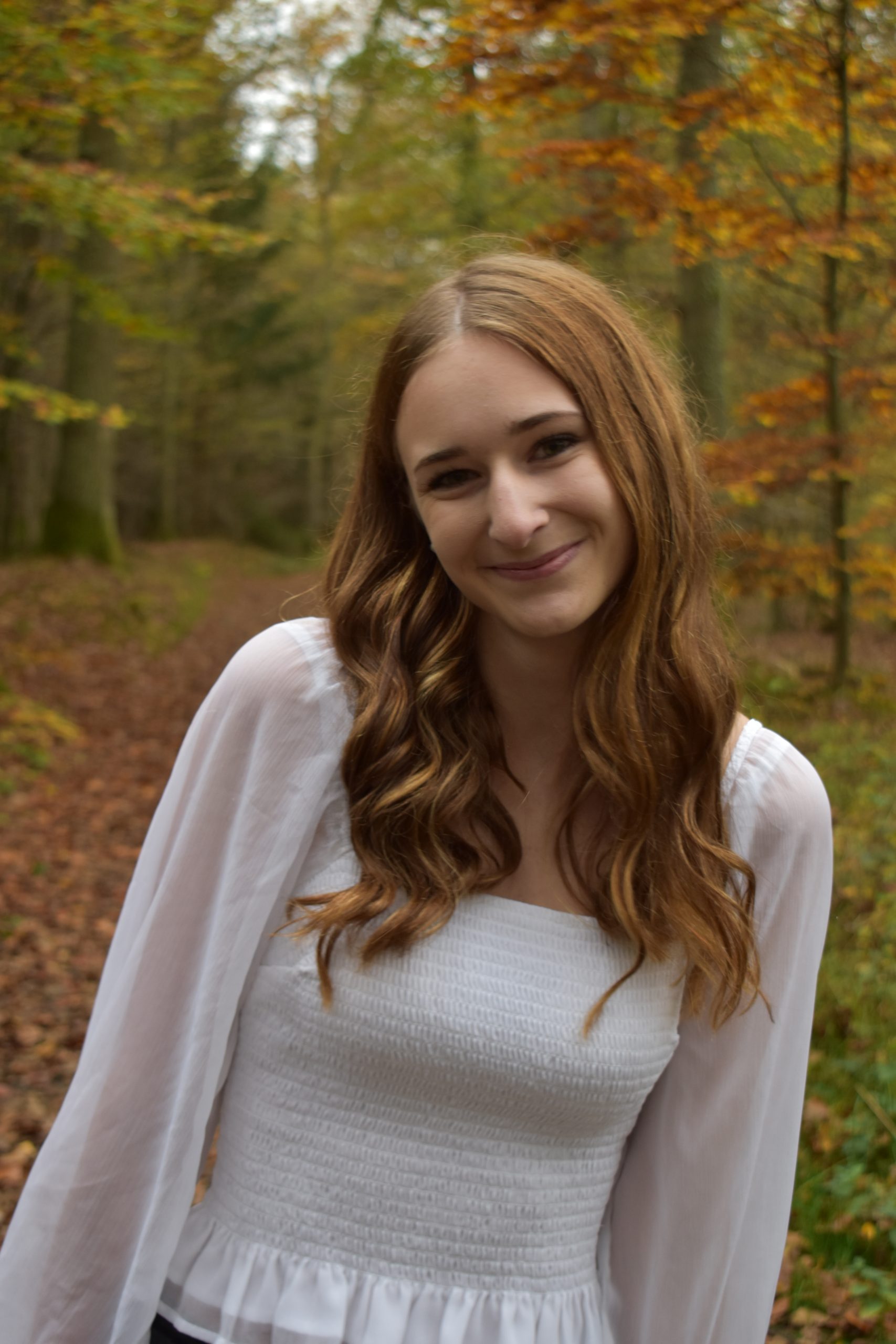 Natascha Eschinger als freie Traurednerin im Wald. Auf dem Boden liegt ganz viel Laub.